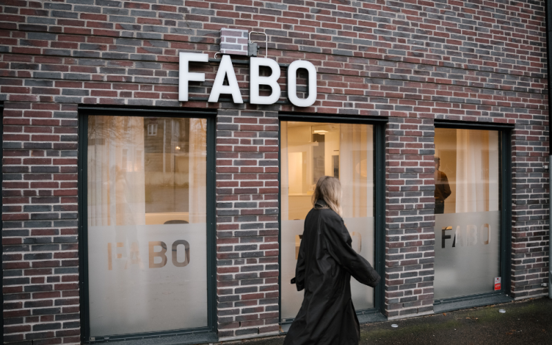Fabos fasad, kvinna går framför
