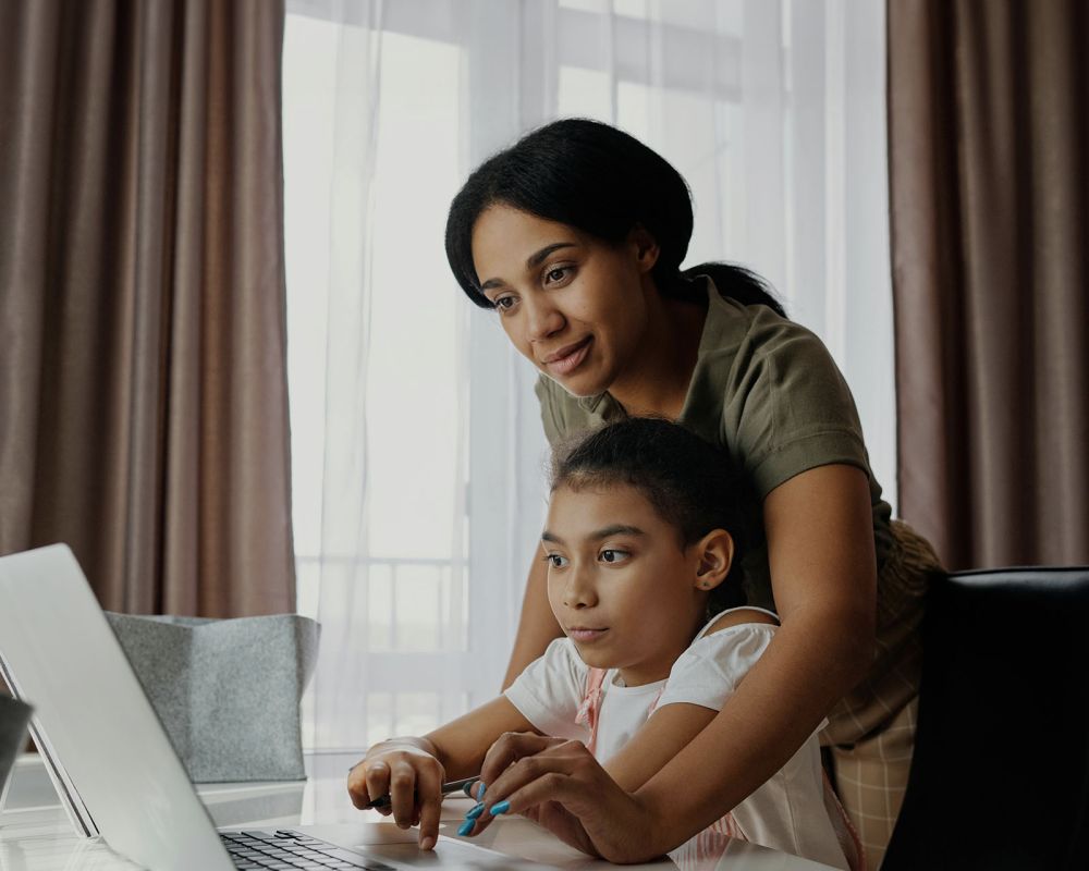 en mamma hjälper dotter med laptop