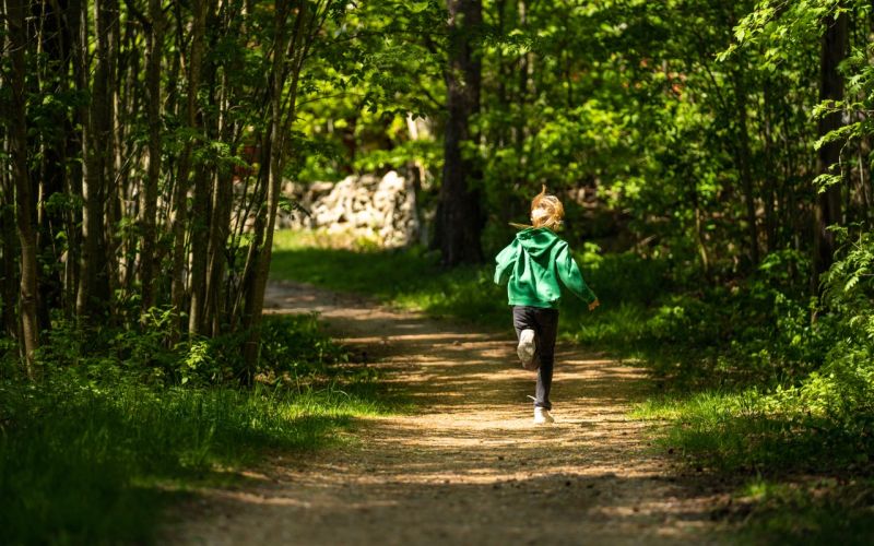 ett barn springer på en grusväg