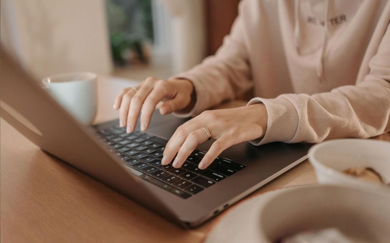 en kvinna skriver på laptop