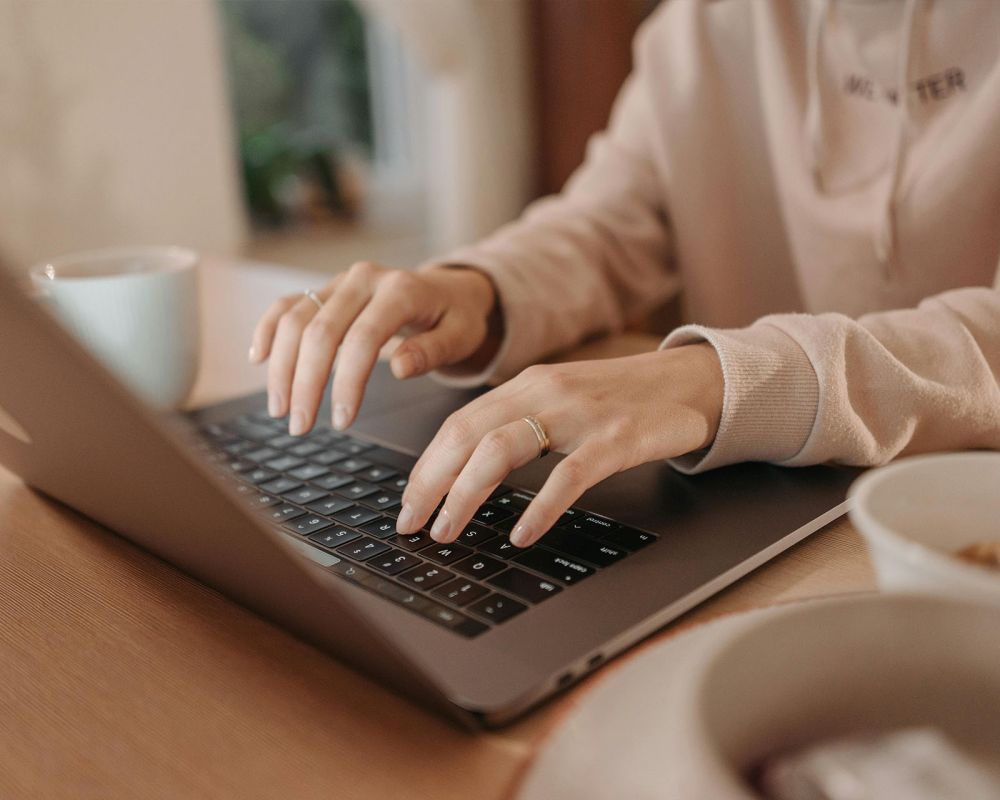 en kvinna skriver på laptop