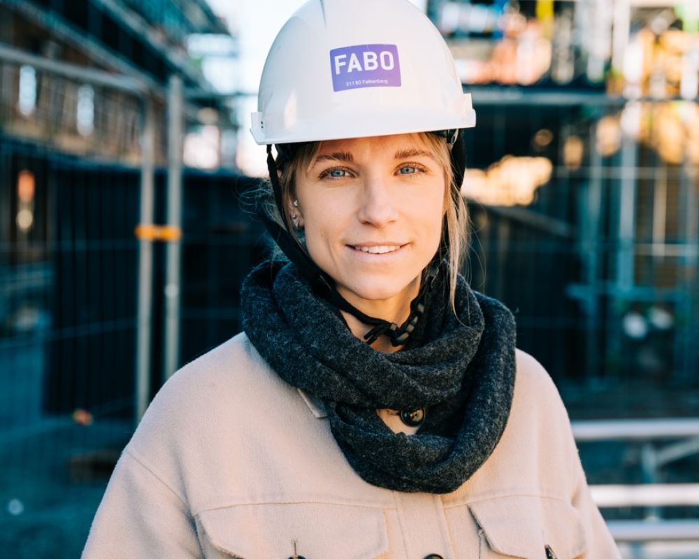 Fabo-anställd med skyddshjälm inspekterar byggarbetsplats