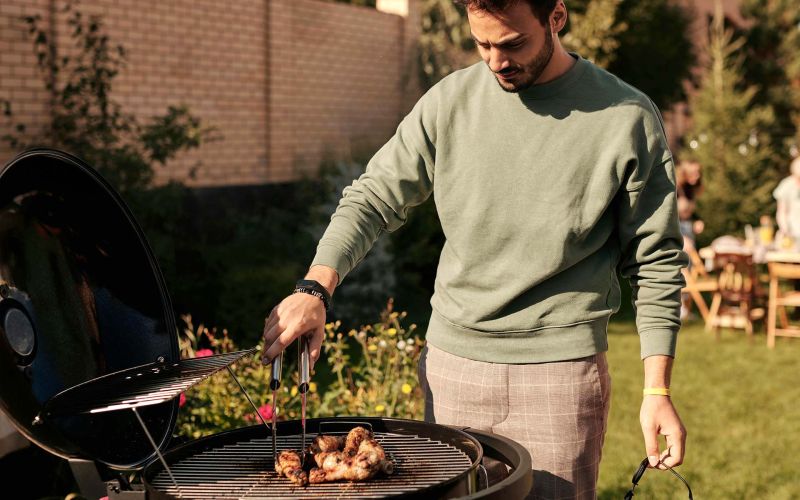 en man står vid en grill